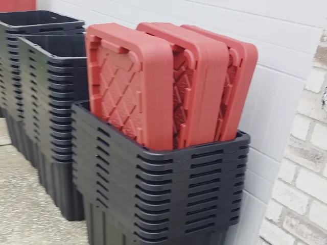Rental moving boxes in Houston: black 27-gallon lidded plastic bins nested in stacks, ready for delivery